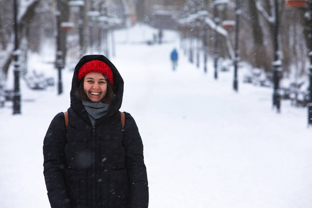glimlachende vrouw portret in de winter outfit in de stad besneeuwd park - Foto, afbeelding