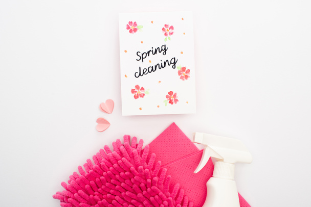 κορυφαία άποψη των ροζ προμήθειες καθαρισμού και καρδιές κοντά στην κάρτα καθαρισμού άνοιξη σε λευκό φόντο - Φωτογραφία, εικόνα