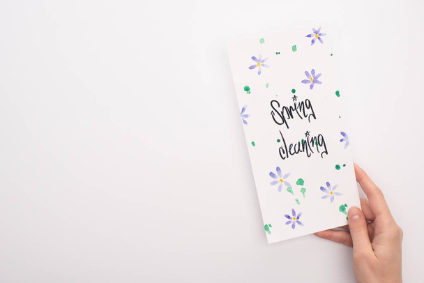cropped view of woman holding spring cleaning card on white background - Foto, Imagen