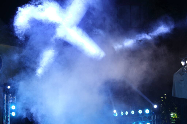 Производительность движущегося освещения на конструкции луч света вниз в желтом синем цвете, на концерте и показе моды рампы сцены с дымом
 - Фото, изображение