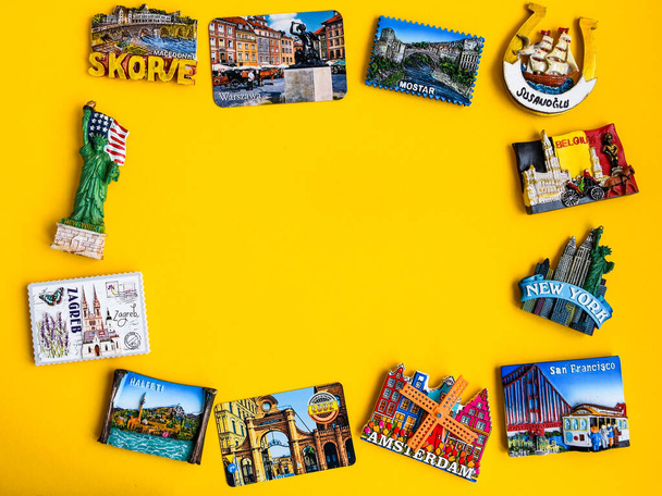 Магниты из разных стран на желтом фоне, концепция путешествия, планирование поездки, копировальное пространство
 - Фото, изображение