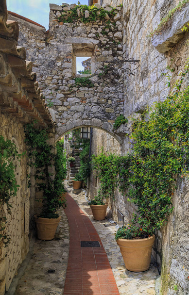 Pedra exterior de edifícios antigos em ruas estreitas na pitoresca cidade medieval de Eze Village, no sul da França, ao longo do Mar Mediterrâneo
 - Foto, Imagem