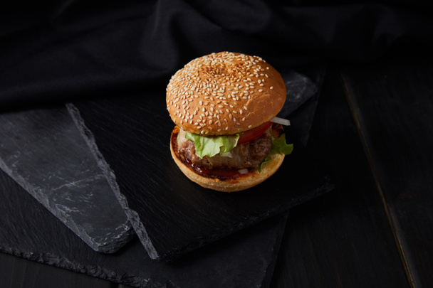 high angle view of burger on black wooden surface - Photo, image