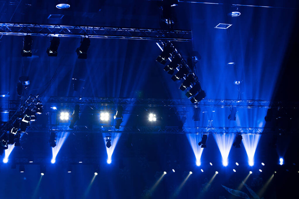 コンサートやファッションショーのステージランプで、黄色の青の色で建設光ビーム線の下に照明を移動するパフォーマンス - 写真・画像