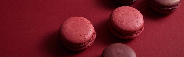 delicious colorful french macaroons on red background, panoramic shot - Φωτογραφία, εικόνα