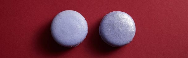 top view of delicious violet colorful french macaroons on red background, panoramic shot - Φωτογραφία, εικόνα