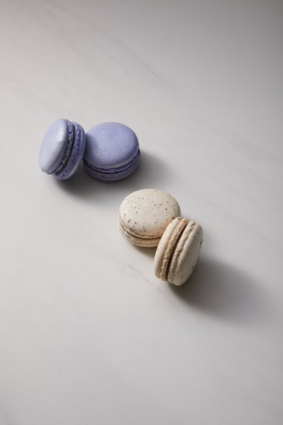 assorted delicious violet and white  french macaroons on grey background - Zdjęcie, obraz
