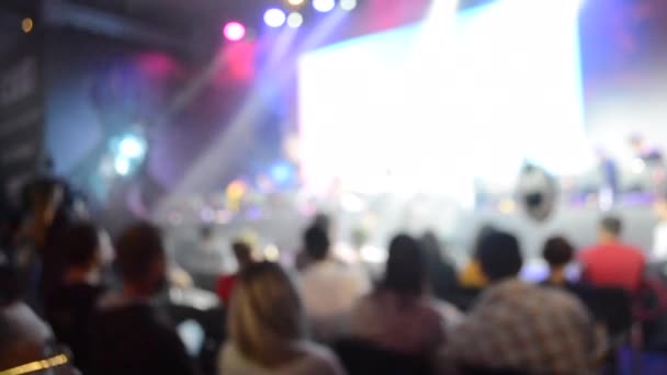 fundo borrado grande tela palco muitas pessoas holofotes multicoloridos
 - Filmagem, Vídeo
