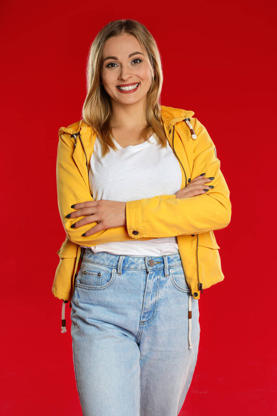Beautiful woman in casual outfit on red background - Foto, afbeelding