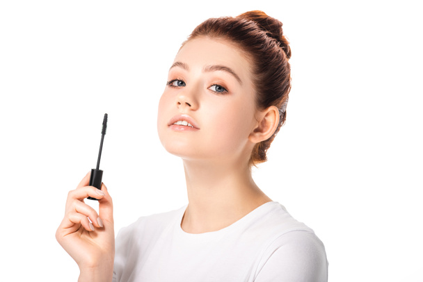 attractive teen girl holding mascara, isolated on white - 写真・画像