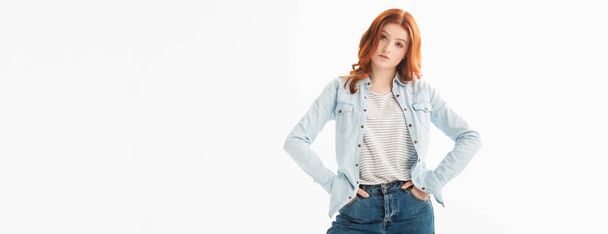 panoramic shot of redhead teenager in denim clothes with akimbo gesture, isolated on white - Foto, imagen