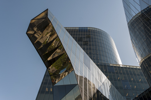 Perspective à angle bas regardant entre deux gratte-ciel commerciaux modernes vers le ciel bleu nuageux
 - Photo, image