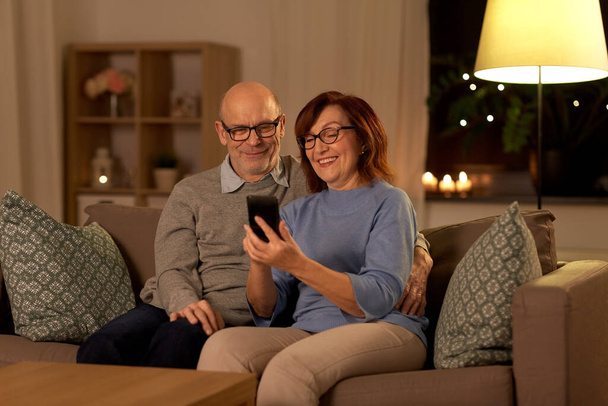 happy senior couple with smartphone at home - Foto, imagen