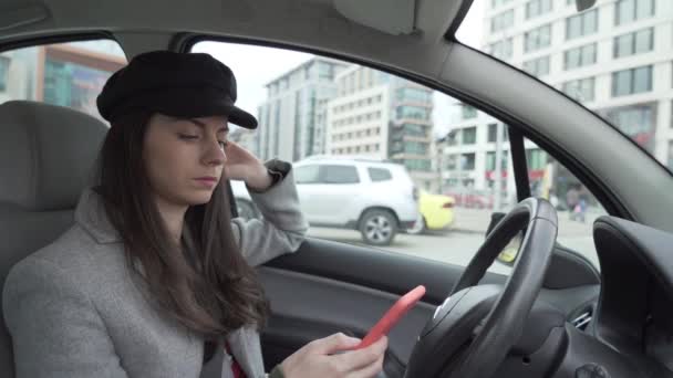 Dziewczyna za pomocą smartfona w samochodzie podczas oczekiwania kogoś - Materiał filmowy, wideo