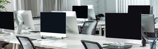 panoramiczne ujęcie biura otwartej przestrzeni z monitorami komputerowymi na białych biurkach - Zdjęcie, obraz
