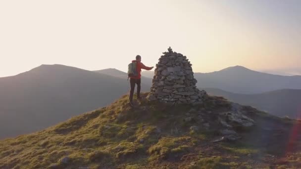 Tourist hiker with a backpack walking on mountain path in Carpathian mountains. Man tourist hiking uphill on rocky desert terrain. - Footage, Video