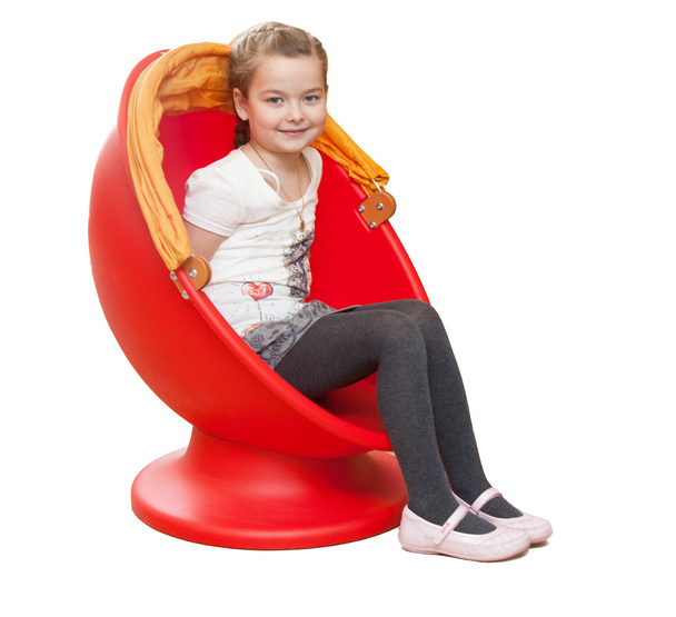 A young girl sits in a red chair - Фото, изображение