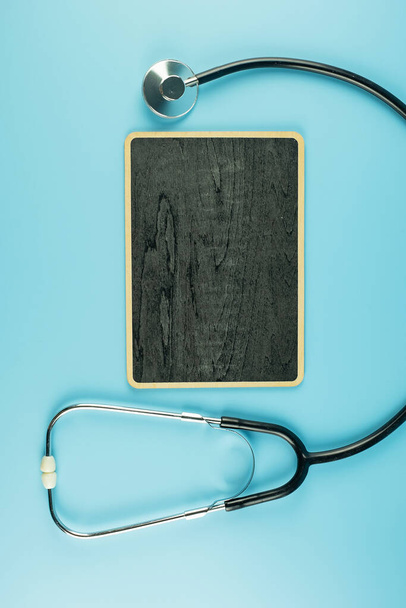 Κάτοψη Stethoscope σε μπλε φόντο με χώρο αντιγραφής για κείμενο. Υγεία, ασφάλεια ζωής, Ημέρα υγείας, Παγκόσμια Ημέρα της Καρδιάς και την έννοια Ευτυχισμένη Ημέρα Γιατρός - Φωτογραφία, εικόνα