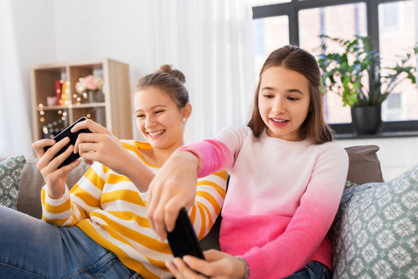 girls and playing game on smartphones at home - Zdjęcie, obraz