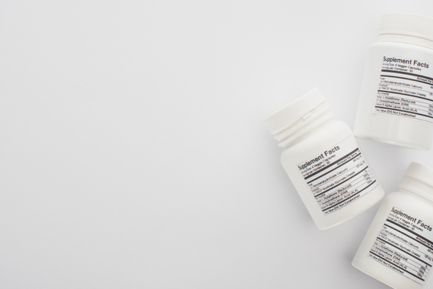 Visão superior de recipientes com suplementos dietéticos em branco
  - Foto, Imagem