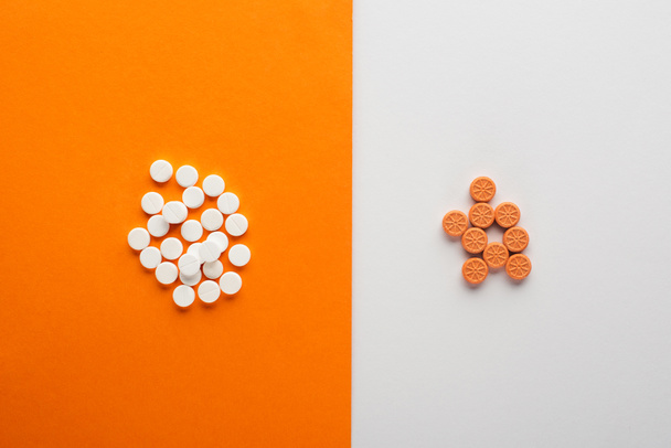 Visão superior de pílulas no fundo branco e laranja
 - Foto, Imagem