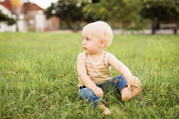 Baby boy sitting on the green grass - Valokuva, kuva