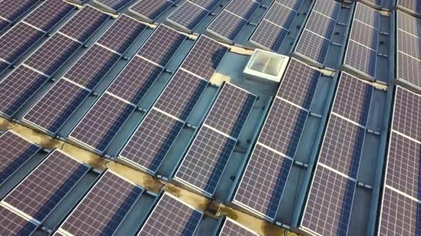 Вид с воздуха на множество фотовольтаических солнечных панелей, смонтированных на крыше промышленного здания. - Кадры, видео