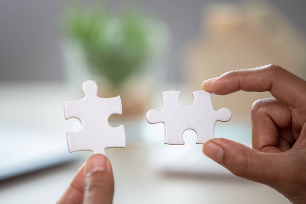 Business woman is trying to connect couple puzzle piece. Symbol of association and connection. Concept of business strategy - Foto, imagen