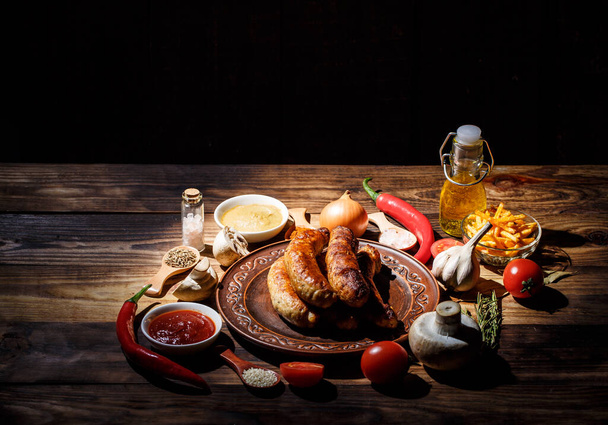 Grilled sausages, fresh vegetables, ingredients and spices on a wooden table - Foto, immagini
