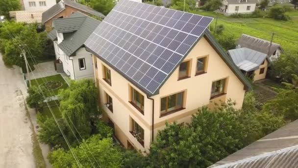 Aerial top view of new modern residential house cottage with blue shiny solar photo voltaic panels system on roof. Renewable ecological green energy production concept. - Footage, Video