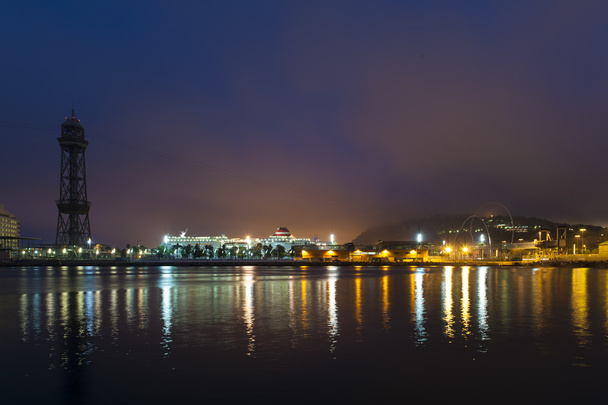 夜の街の照明から、水と空に輝きを踊る反映されたライトのカラフルな梁を有する沿岸都市の景観 - 写真・画像