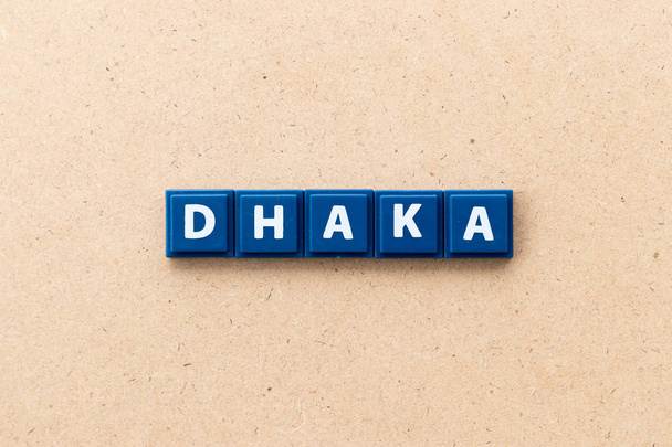 Tile letter in word Dhaka on wood background - 写真・画像
