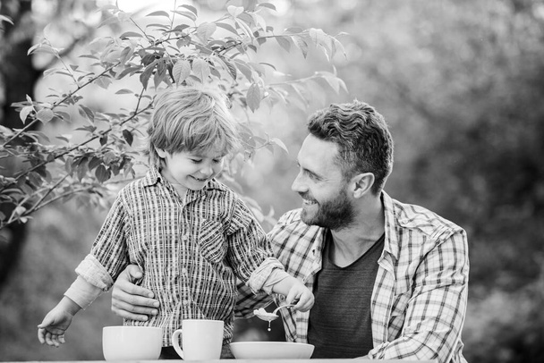 Happy family together. Child development. childhood happiness. healthy food and dieting. Family day. happy fathers day. Little boy with dad outdoor. son and father eating milk porridge. Good food - Foto, immagini