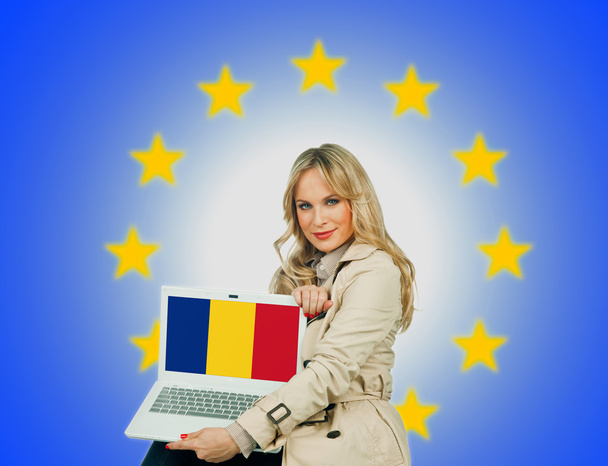 женщина держит ноутбук с румынским флагом
 - Фото, изображение