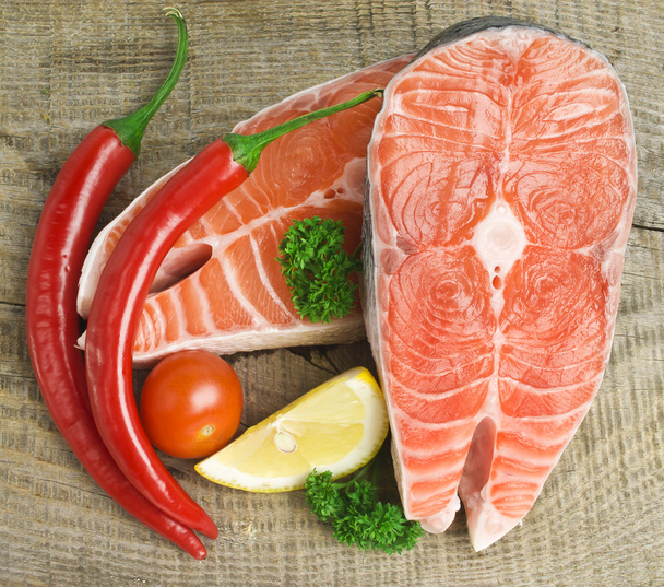 Raw salmon, vegetables and spices on an old wooden table - 写真・画像