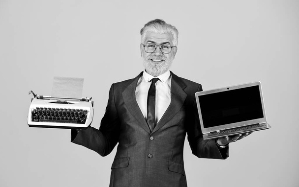 Distant Education. modern digital business. vintage typewriter. successful businessman retro typewriter and modern laptop. mature man dyed beard hair. computer or typewriter. new and old technology - Foto, afbeelding