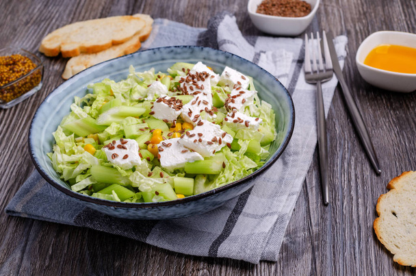 Zeleninový salát se sýrem Feta a lněnými semínky na dřevěném pozadí. Selektivní zaměření. - Fotografie, Obrázek