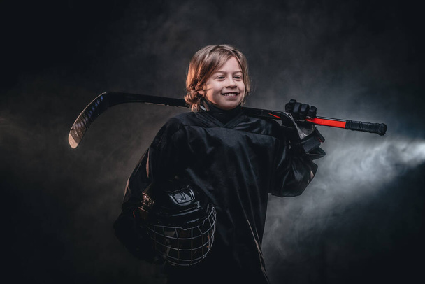 Giovane giocatore di hockey sorridente in posa in uniforme per una foto in uno studio
 - Foto, immagini