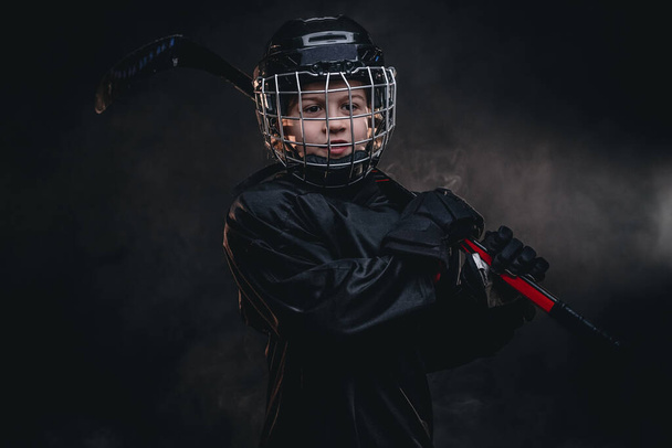 8-10 year old smiling hockey player posing in uniform for a photoshot in a studio - Foto, afbeelding