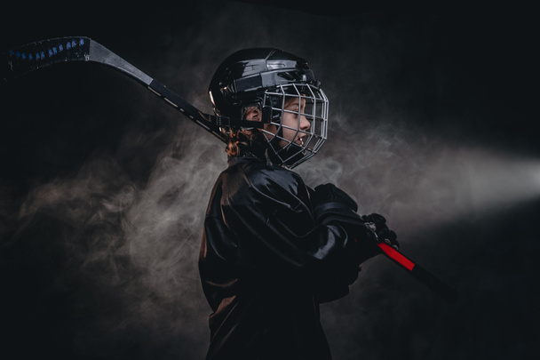 Молодой уверенный хоккеист позирует в форме для фотосессии в студии с хоккейной экипировкой
 - Фото, изображение