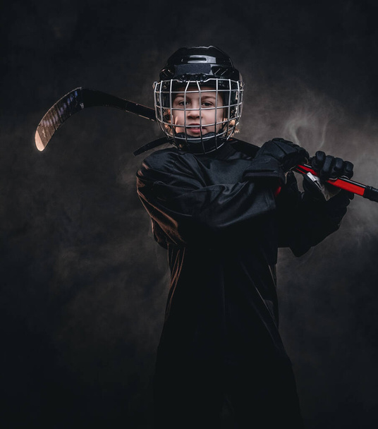 Niño de 8-10 años, jugador de hockey posando en uniforme con equipo de hockey para una foto en un estudio
 - Foto, Imagen