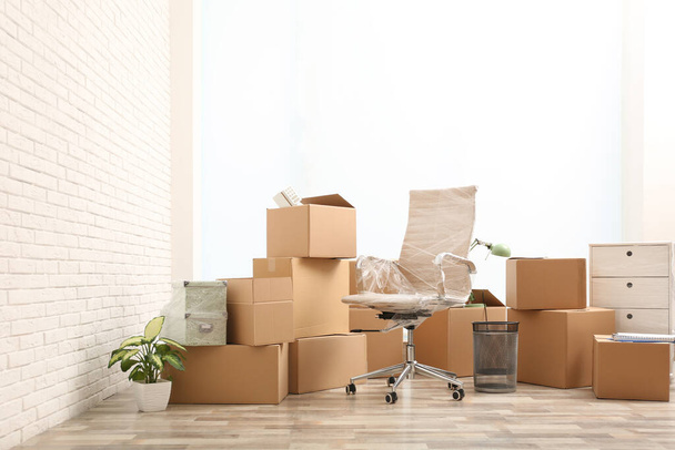 Moving boxes and stuff near white brick wall in room - 写真・画像