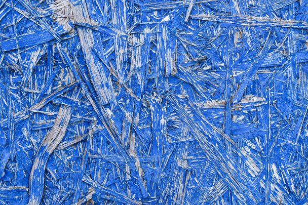 木の質感と青の抽象的な背景。塗装OSBパネル。木材チップ粒子ボード構築材料の詳細なビュー鮮やかな青の色で. - 写真・画像