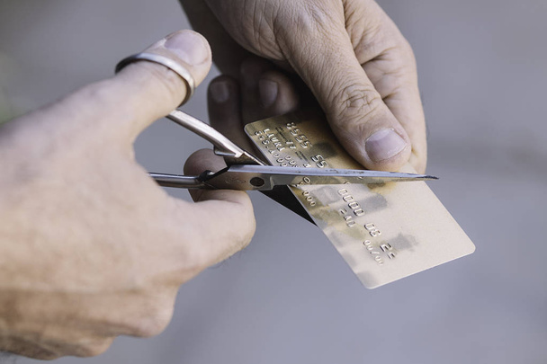 Hand cutting a credit card with scissors - 写真・画像