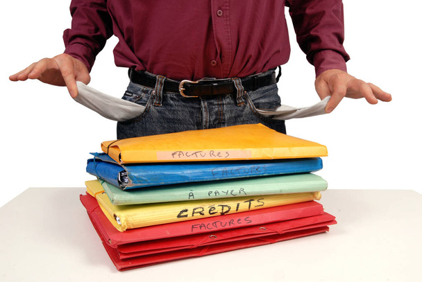 Hombre endeudado con bolsillos vacíos y archivos de crédito y facturas
  - Foto, Imagen