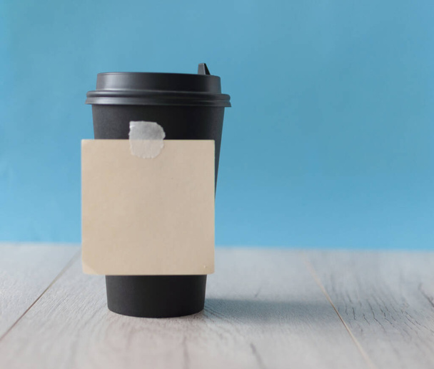Single black disposable paper cup with lids on colorful paper background - Zdjęcie, obraz
