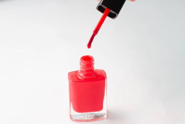 a red nail polish with a drop of brush on white background - Photo, Image