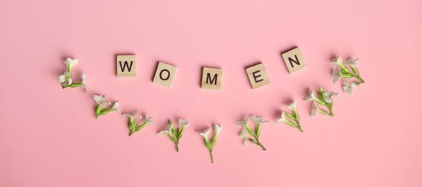 Frauen von oben buchstabiert in Holzklötzen auf rosa Hintergrund. Liebe, 8. März. Geschenk, Gruß, Kompliment. Kopierraum. Platz für Text. - Foto, Bild