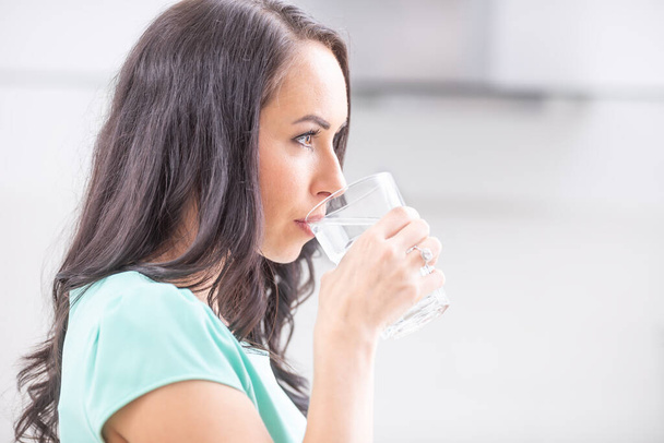 νεαρή γυναίκα πίνει καθαρό νερό εμμένει στο καθεστώς κατανάλωσης. - Φωτογραφία, εικόνα