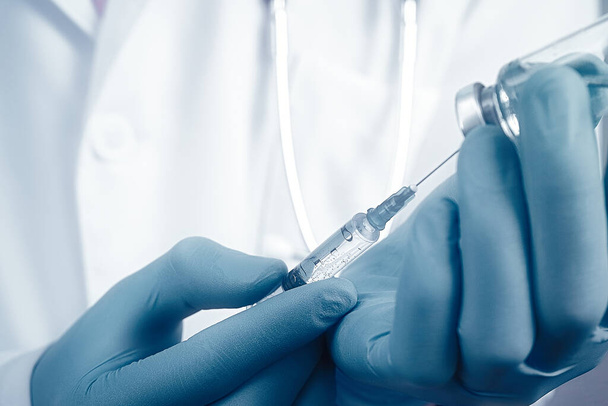 Feche o braço do médico usando seringa e ampola, roupão branco vestido de médico em fundo borrado. Conceito médico, imunização e vacinação - Foto, Imagem